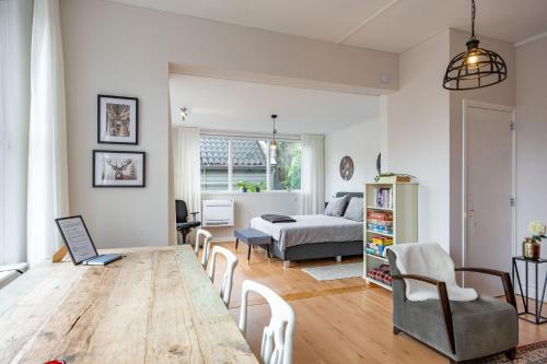 a living room with a wooden table and a bed at Onder de Beukenboom in Nieuwe Pekela