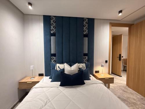 a bedroom with a large bed with a blue headboard at Jolie studio plein centre Casablanca in Casablanca