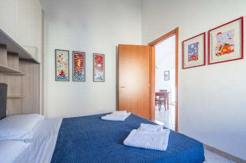 a bedroom with a blue bed with two towels on it at Creuza de Cinque Terre Apartment in Volastra