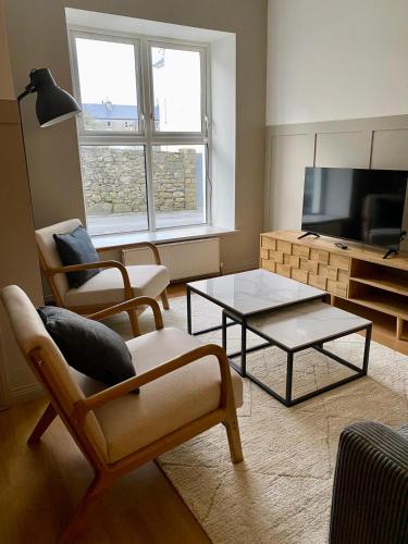 a living room with two chairs and a coffee table at The Old Shop Apartment in Rathmullan