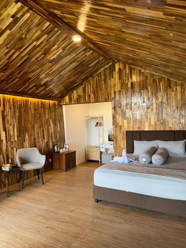 a bedroom with a bed and a wooden ceiling at YSR Himalaya Resort in Mantaak