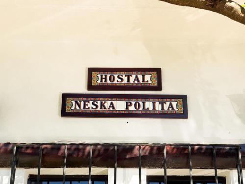 a sign on the side of a building at Neska Polita Hostel in Juayúa
