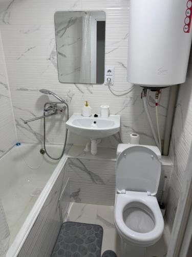 a white bathroom with a toilet and a sink at AeroHome Moldova- TAXI-PARKING ! in Chişinău