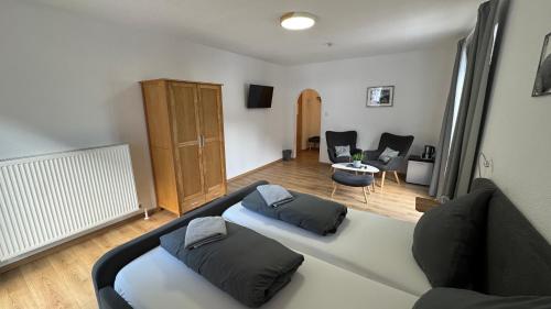 a room with a bed and a living room with chairs at Pension Bergfried in Hallstatt