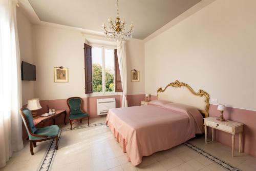 a bedroom with a bed and two chairs and a window at il buen retiro in Lucca