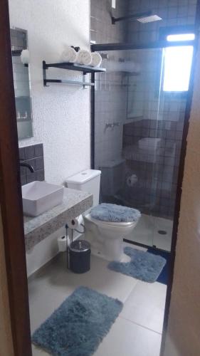 a bathroom with a toilet and a sink and a shower at Recanto Apoena in Santa Isabel