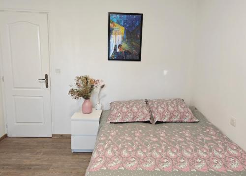 a bedroom with a bed and a painting on the wall at Jolie chambre au centre Antony in Antony