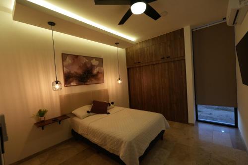 a bedroom with a bed and a ceiling fan at Casa Morrocoy con alberca privada y 3 habitaciones in Cholul