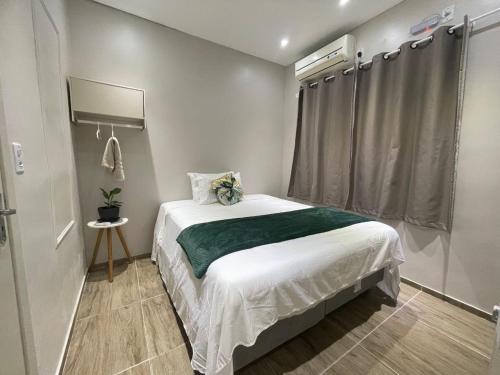a small bedroom with a bed and a window at Refúgio Vida & Brisa in Pelotas