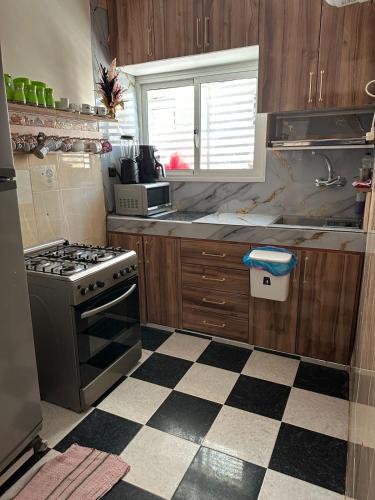 a kitchen with a stove and a checkered floor at Amazing apartment with traditional touch in Taskala