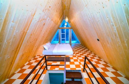 an attic room with a bed and a window at Raj Villas by Jomotel - A Riverside Retreat in Banjār
