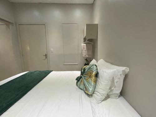 a white bed with a pillow with a bow on it at Refúgio Vida & Brisa in Pelotas