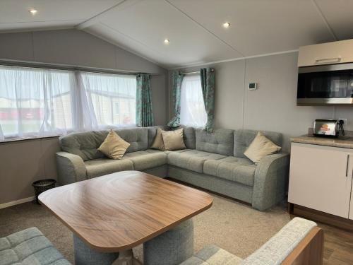 a living room with a couch and a table at Perranporth Beach 3 Bed Holiday Home Cornwall. in Perranporth