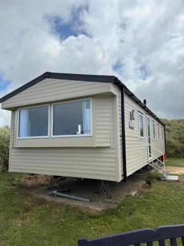 a large white trailer parked in the grass at Perranporth Beach 3 Bed Holiday Home Cornwall. in Perranporth