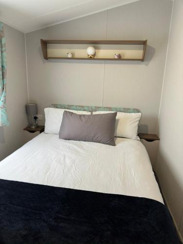 a bedroom with a bed with white sheets and pillows at Perranporth Beach 3 Bed Holiday Home Cornwall. in Perranporth