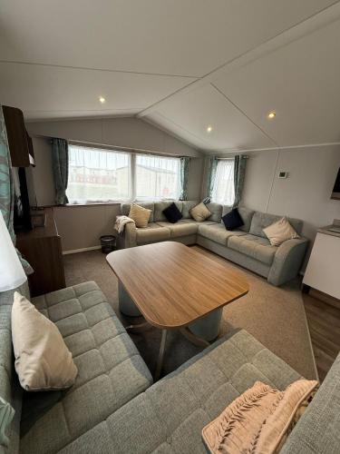 a living room with a couch and a table at Perranporth Beach 3 Bed Holiday Home Cornwall. in Perranporth