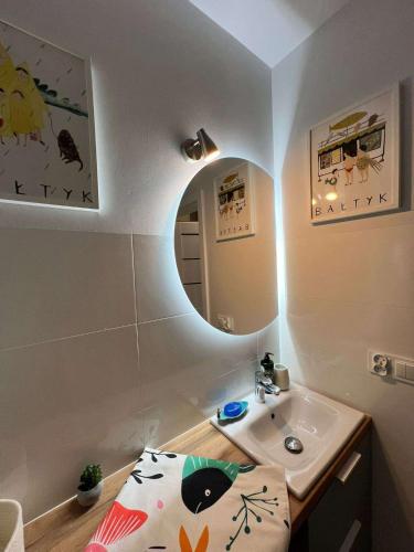 a small bathroom with a sink and a mirror at Mewa Studio in Krynica Morska