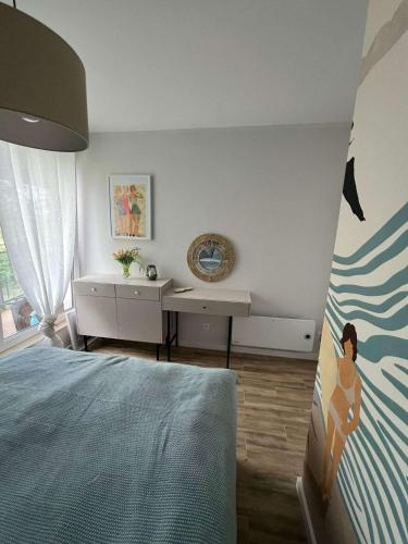 a bedroom with a bed and a desk in it at Mewa Studio in Krynica Morska