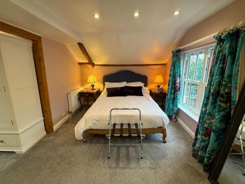 a bedroom with a bed and two tables and a window at No93 Boutique Guest House in Easingwold