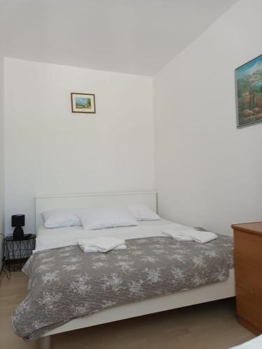 a bed in a room with a white wall at Apartment Gajac A7 44 in Novalja