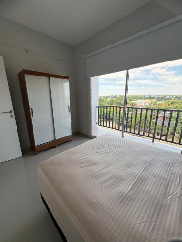 a bedroom with a large bed and a large window at Departamento 1 dormitorio con piscina in Fernando de la Mora