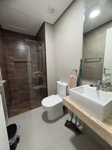 a bathroom with a toilet and a sink and a shower at Departamento 1 dormitorio con piscina in Fernando de la Mora