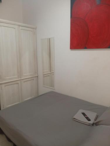 a white room with a bed and a painting on the wall at Cantinho in Rio de Janeiro