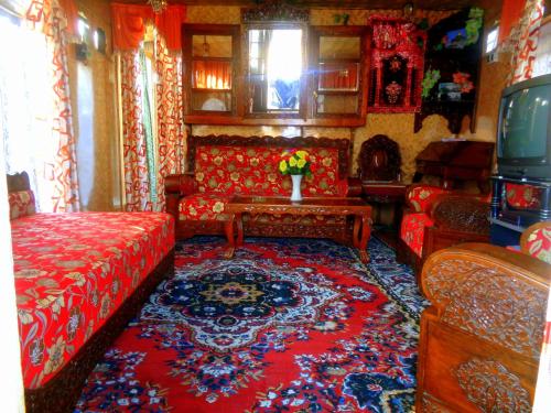 sala de estar con sofá rojo y alfombra en H B RAH Group Of Houseboats, en Durgjan