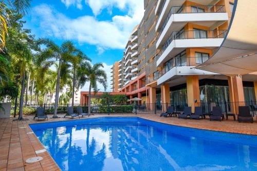 a hotel room with a pool and a balcony at Mantra on The Esplanade in Darwin