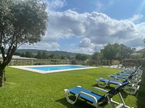 a row of lounge chairs next to a swimming pool at Quinta do Sobrado in Braga
