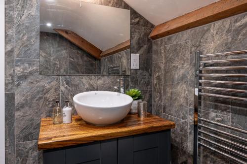 a bathroom with a white bowl sink on a wooden counter at No93 Boutique Guest House in Easingwold