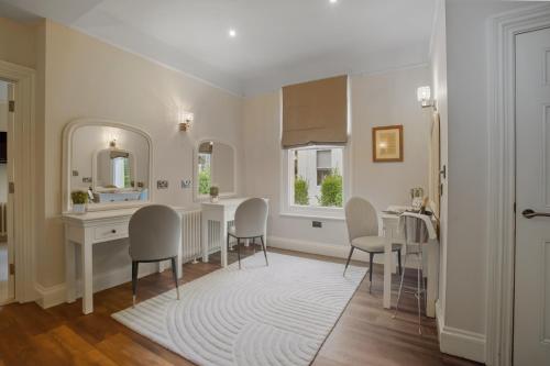 a dining room with white chairs and a dining table at St Elizabeth's House in Plymouth
