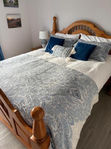a bedroom with a large bed with blue pillows at Moneydarragh Cottage with uninterrupted mountain and sea views- Hot tub available for hire at extra cost in Annalong