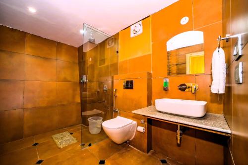a bathroom with a toilet and a sink at Raj Villas by Jomotel - A Riverside Retreat in Banjār