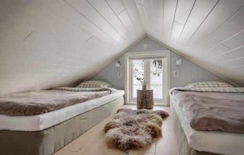 a attic room with two beds and a window at Panoramic View of Voss - Private Cabin & Patio in Vossevangen