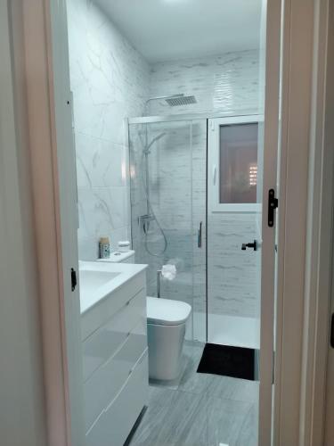 a white bathroom with a shower and a toilet at Rosa de la Sal in La Mata