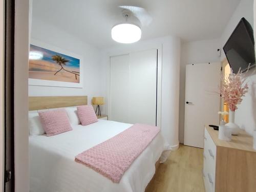 a bedroom with a white bed with pink pillows at Rosa de la Sal in La Mata