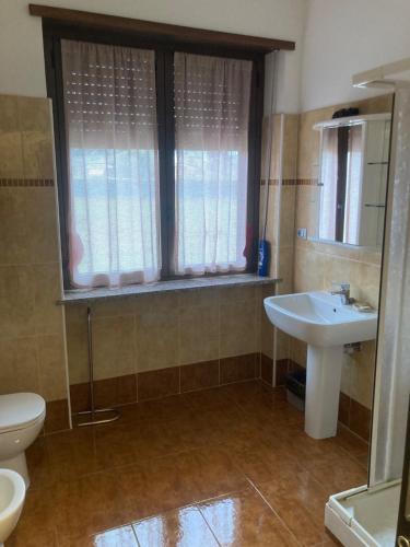 a bathroom with a sink and a toilet and a window at La Mandulera in Rivalta di Torino