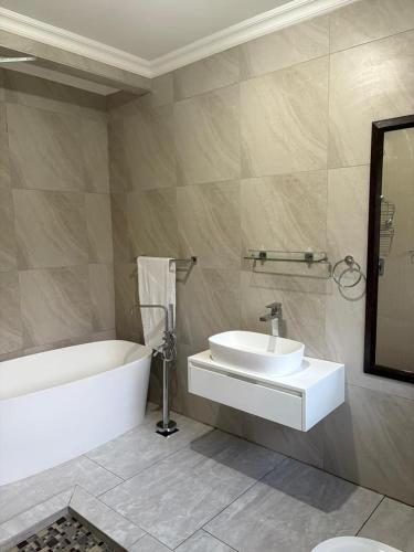 a bathroom with a white tub and a sink at Swakhanya Haus in Vereeniging