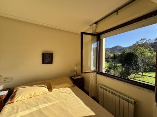 a bedroom with a bed and a large window at Casa Los Campones en Asturias VV-3585-AS in Nava