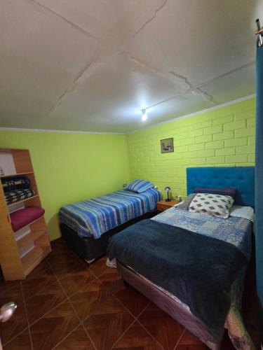 two beds in a room with green walls at Margaret in Combarbalá
