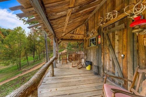 a porch of a wooden cabin with a table and chairs at Squatter's Cabin (Off-Grid): Includes 1-UTV in Jasper