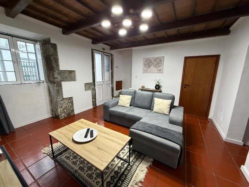 a living room with a couch and a table at Casa de Santo Amaro in Ribeirinha