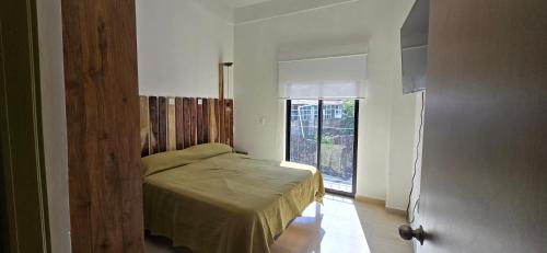 a bedroom with a bed in a room with a window at New, modern, amazing terrace in Taxco de Alarcón