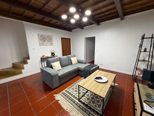 a living room with a couch and a table at Casa de Santo Amaro in Ribeirinha