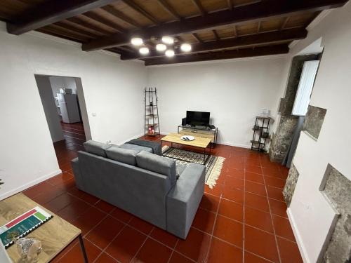 a living room with a couch and a table at Casa de Santo Amaro in Ribeirinha