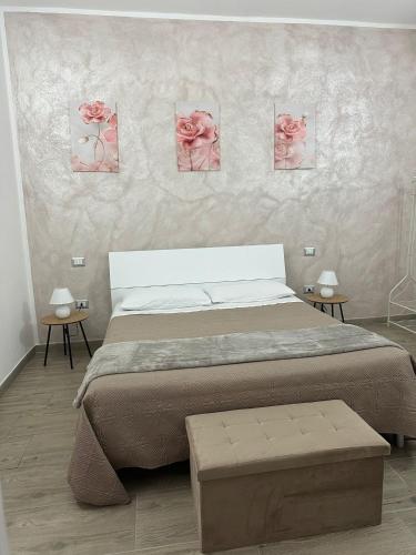 ein Schlafzimmer mit einem Bett und rosa Rosen an der Wand in der Unterkunft S'Istella Affittacamere in Tinnura