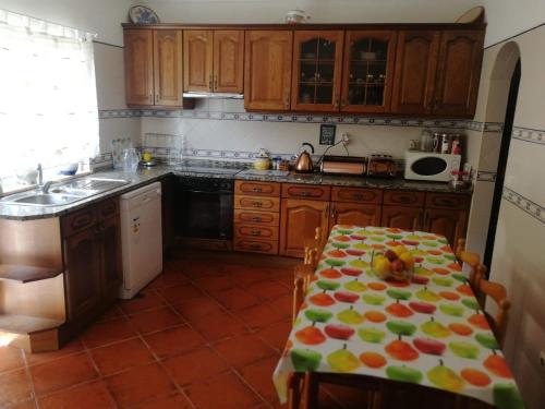 a kitchen with a table with fruits on it at The Lemon Tree House in Quinta do Conde