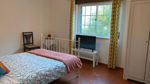 a bedroom with a bed and a window at The Lemon Tree House in Quinta do Conde