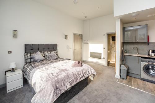 a bedroom with a bed and a washing machine at Edgerton Stays in Huddersfield